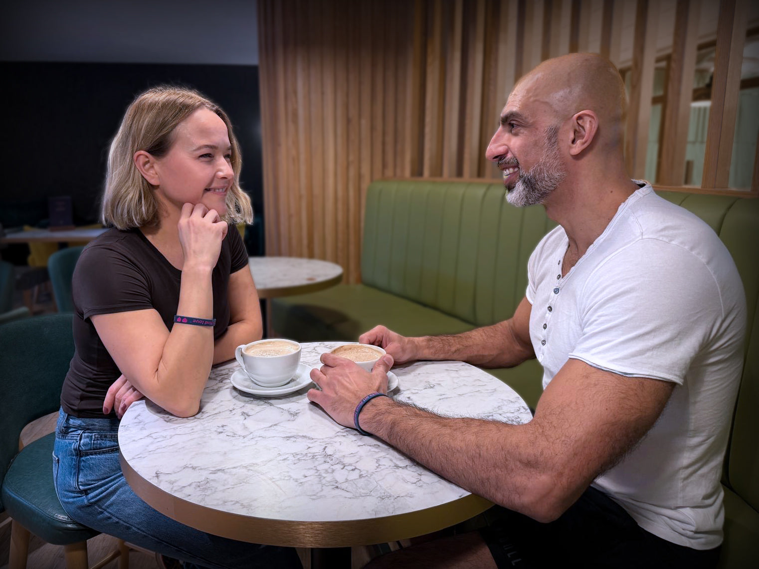 Attractive couple on a coffee date after finding each other at the gym