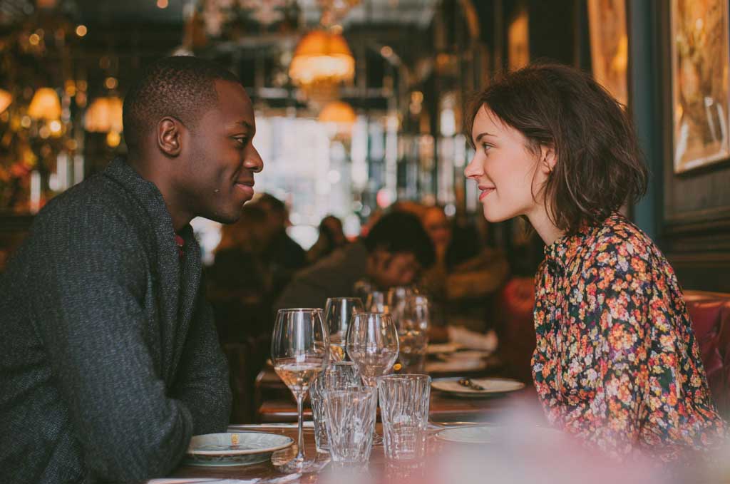 Success story, a couple on a dinner date after meeting while wearing the lets all find love wristbands